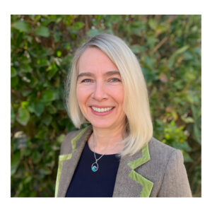 Portrait photo of smiling woman in front of hedges